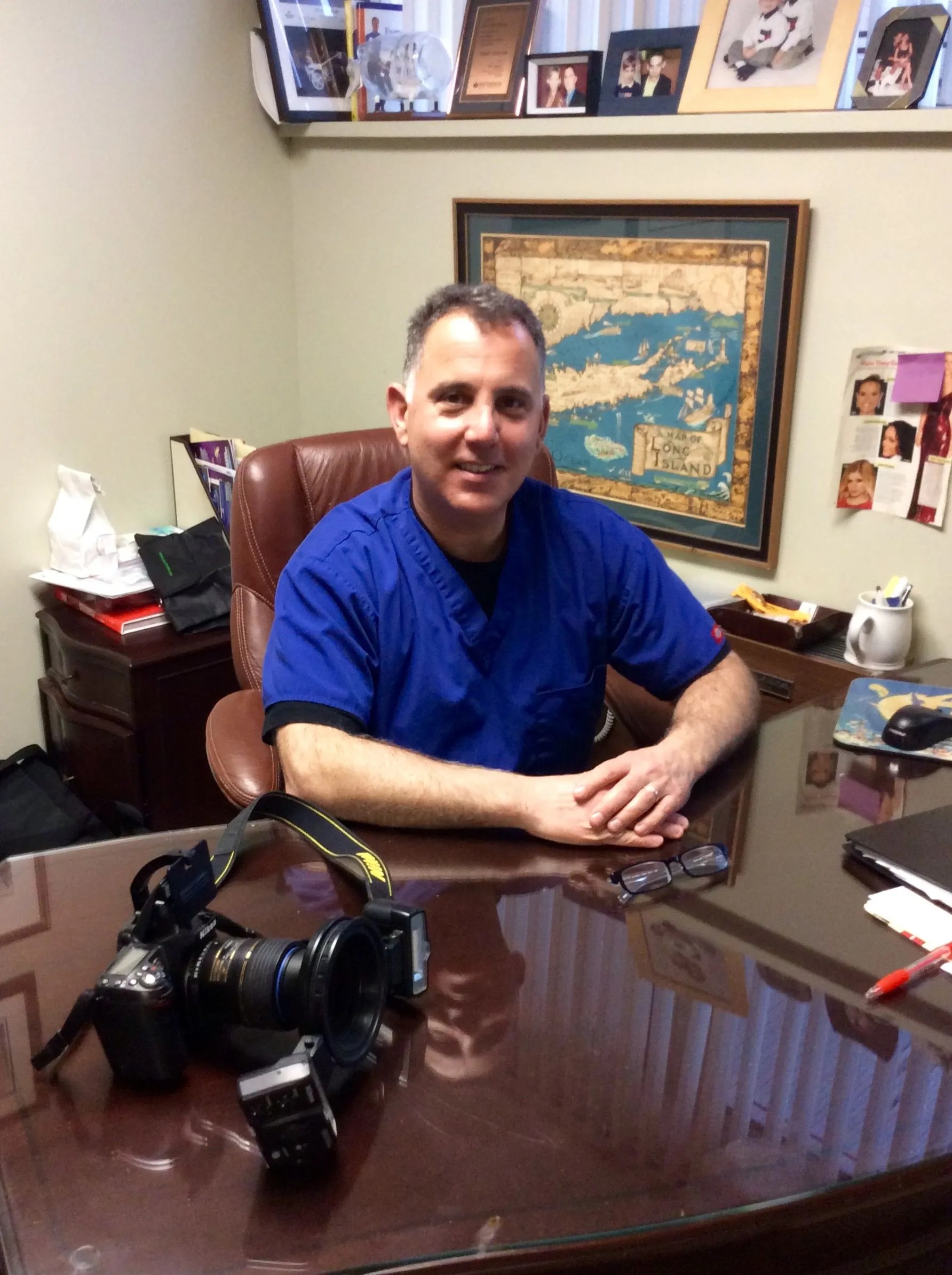 Portrait of Dr. Buono seated in a dental office consultation room.