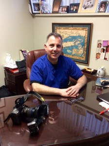 Portrait of Dr. Buono seated in a dental office consultation room.