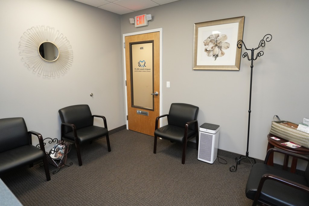 Comfortable dental office waiting area with chairs and reception decor.