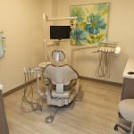 Clean and modern dental exam room with dental chair and instruments.