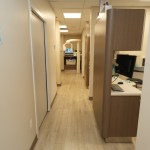 Hallway inside a modern dental clinic with treatment rooms and workstations.
